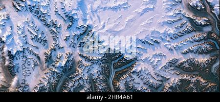 Shedding light on Greenland, top view of ice sheet texture,melt ponds, snowy mountain peaks cast long shadows.Elements of this image furnished by NASA Stock Photo