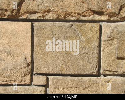 Background natural stone wall rectangular geometric illuminated by the sun. Stock Photo