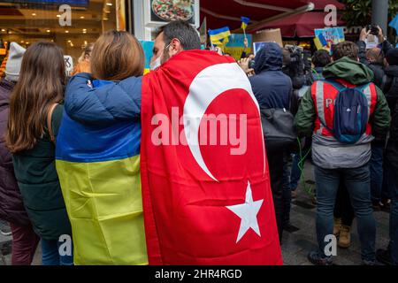 February 25, 2022: On the second day of the protests, Ukrainian citizens living in Istanbul condemned the Russian intervention in Ukraine with slogans and banners. The demonstrators, holding banners and Ukrainian flags, gathered on Istiklal Street and chanted slogans against Russia and Putin in front of the Russian Consulate General in Istanbul, Turkey on February 25, 2022. The police set up a barrier with their bodies in front of the demonstrators to prevent them from entering the crowded Istiklal Street. The protesters demanded an end to the war. Turkish citizens also supported the protest. Stock Photo