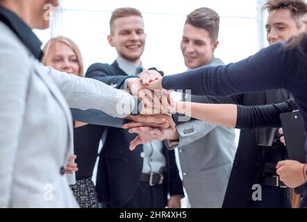 young employees making a stack out of their hands Stock Photo