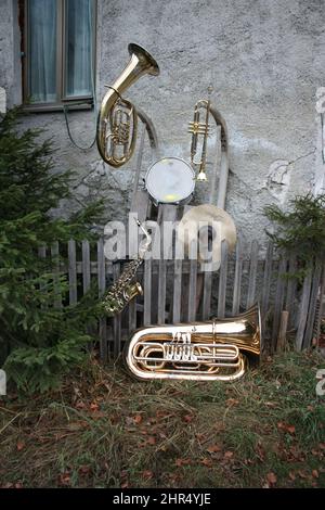 Musical instruments including tuba, trumpet, saxophone and drum on an old wall Stock Photo