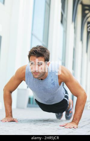 Two-hundred-and-six.... Toned young man doing push-ups - copyspace. Stock Photo