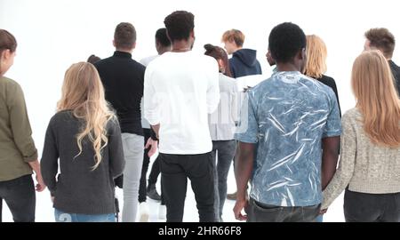 a group of young people stand with their backs looking into the Stock Photo