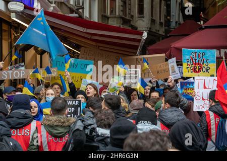 February 25, 2022: On the second day of the protests, Ukrainian citizens living in Istanbul condemned the Russian intervention in Ukraine with slogans and banners. The demonstrators, holding banners and Ukrainian flags, gathered on Istiklal Street and chanted slogans against Russia and Putin in front of the Russian Consulate General in Istanbul, Turkey on February 25, 2022. The police set up a barrier with their bodies in front of the demonstrators to prevent them from entering the crowded Istiklal Street. The protesters demanded an end to the war. Turkish citizens also supported the protest. Stock Photo