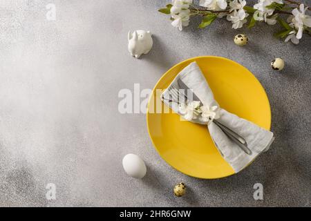 Easter festive table setting with spring green decoration and colorful eggs. View from above. Copy space. Stock Photo