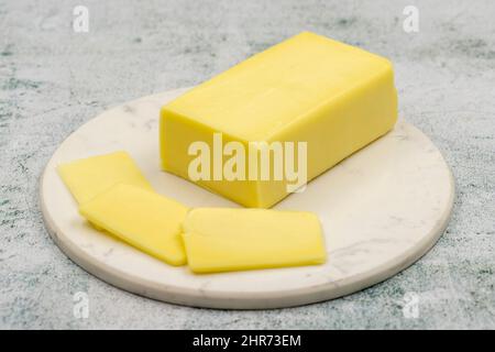 Kashar cheese or kashkaval cheese on stone background. Sliced Cheddar Cheese Stock Photo