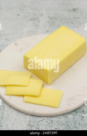 Kashar cheese or kashkaval cheese on stone background. Sliced Cheddar Cheese Stock Photo