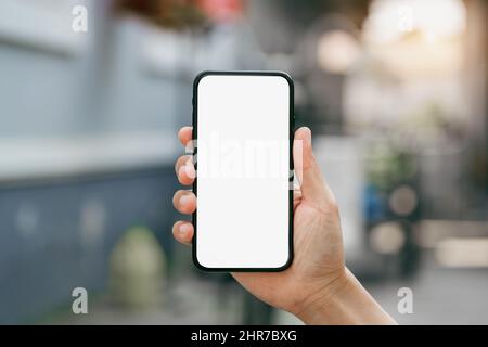 Male hand holding smartphone with white screen. Stock Photo