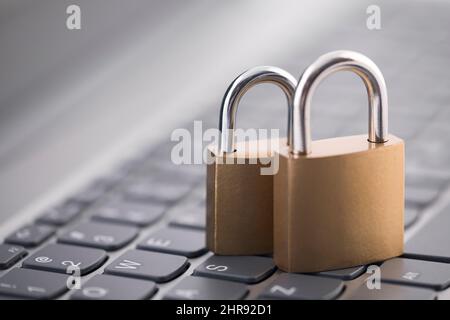 Security concept with two metal padlocks on computer keyboard Stock Photo