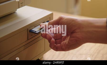 Hand inserting and ejecting Floppy Disk into vintage Commodore Amiga 2000 PC. Popular Gaming PC in the 80s and 90s. Stock Photo