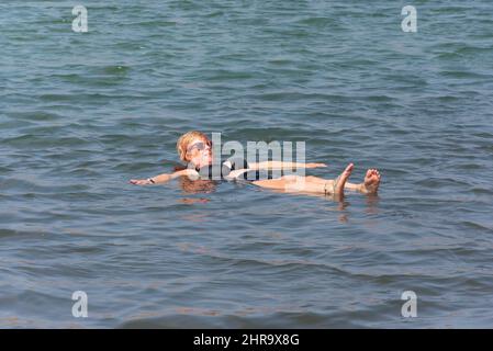 Woman floating in salt evaporation ponds in crater lake, Pedra de Lume, Sal (IIha do Sal), República de Cabo (Cape Verde) Stock Photo