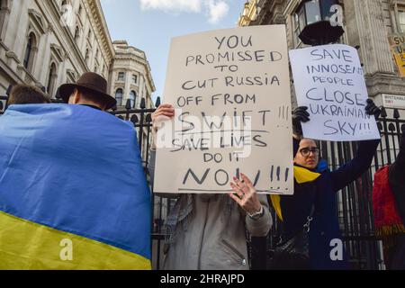 London, UK. 25th February 2022. A protester calls on the UK Government to cut Russia off from SWIFT. Demonstrators gathered outside Downing Street in protest against the Russian invasion of Ukraine, and called on the UK Government to help Ukraine and place additional sanctions on Russia. Credit: Vuk Valcic/Alamy Live News Stock Photo