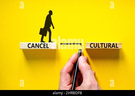 Cancel cultural symbol. Concept words Cancel cultural on wooden blocks on a beautiful yellow table yellow background. Businessman hand. Business and c Stock Photo