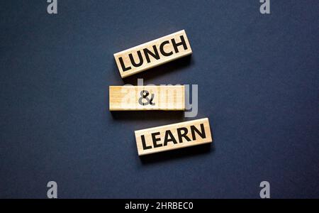 Lunch and learn symbol. Concept words Lunch and learn on wooden blocks. Beautiful black table black background. Copy space. Business, educational and Stock Photo