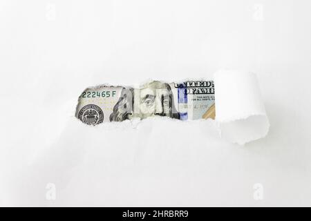 Benjamin Franklin portrait on 100 banknote in torn paper hole. Benjamin Franklin's eyes from a hundred-dollar bill Stock Photo