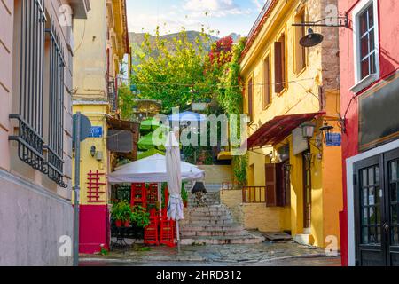 A colorful hillside alley in the Plaka district of Athens, Greece, with cafes and shops at the base of the ancient Acropolis. Stock Photo