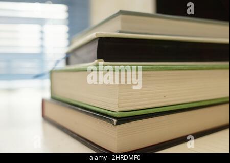 A closeup of a stack of books on a table with a blurry background Stock Photo