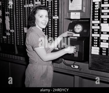 1940s WORLD WAR 2 WOMAN DEFENSE WORKER IN ROLLER BEARING COMPANY PUNCHING IN TIME CLOCK SMILING LOOKING AT CAMERA  - i3590 HAR001 HARS LIFESTYLE SATISFACTION CONFLICT FEMALES WW2 JOBS UNITED STATES COPY SPACE HALF-LENGTH LADIES PERSONS INSPIRATION UNITED STATES OF AMERICA CONFIDENCE B&W NORTH AMERICA EYE CONTACT NORTH AMERICAN SUCCESS WIDE ANGLE SKILL OCCUPATION HAPPINESS SKILLS CHEERFUL GLOBAL STRENGTH VICTORY CHOICE EFFORT EXCITEMENT POWERFUL PROGRESS WORLD WARS LABOR PRIDE WORLD WAR WORLD WAR TWO WORLD WAR II IN EMPLOYMENT OCCUPATIONS PUNCHING SMILES CONCEPTUAL COMPANY JOYFUL STYLISH Stock Photo
