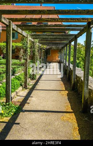 Wooden logs over a pathway against a building Stock Photo