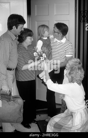 1980s FAMILY AT FRONT DOOR VISITING RELATIVES MAN HOLDING GRANDDAUGHTER WOMAN HANDING BOUQUET OF FLOWERS TO GRANDMOTHER - j14976 RES001 HARS OLD TIME NOSTALGIA OLD FASHION BOUQUET JUVENILE WELCOME COMMUNICATION GENERATIONS GRANDFATHER SONS FAMILIES JOY LIFESTYLE PARENTING CELEBRATION ELDER FEMALES GRANDPARENT RELATION HUSBANDS HOME LIFE COPY SPACE PEOPLE CHILDREN FRIENDSHIP FULL-LENGTH HALF-LENGTH DAUGHTERS PERSONS CARING MALES SENIOR MAN SENIOR ADULT DOORWAYS FATHERS HUSBAND AND WIFE B&W PATERNAL PARENT AND CHILD SENIOR WOMAN HUSBANDS AND WIVES RELEASES MATERNAL HAPPINESS EXCITEMENT EXTERIOR Stock Photo