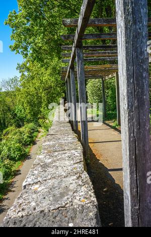 Wooden logs over a pathway against a building Stock Photo