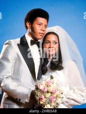 1970s PORTRAIT OF AFRICAN AMERICAN BRIDE AND GROOM LOOKING AT ONE ANOTHER  MAN IN TUXEDO WOMAN WEARING GOWN VEIL HOLDING BOUQUET - kb8759 HAR001 HARS  BOUQUET STYLE YOUNG ADULT TEAMWORK ROSE STRONG