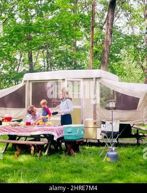 1970s FAMILY FATHER MOTHER AND SON TOGETHER OUTDOORS AROUND CAMPGROUND PICNIC TABLE BESIDE POP-UP FOLD-DOWN CAMPING TRAILER  - kc7839 PHT001 HARS PAIR COLOR MOTHERS OLD TIME FUTURE NOSTALGIA TRAILER OLD FASHION 1 JUVENILE VEHICLE YOUNG ADULT TEAMWORK SONS FAMILIES JOY LIFESTYLE FEMALES MARRIED RURAL SPOUSE HUSBANDS HEALTHINESS HOME LIFE NATURE COPY SPACE FRIENDSHIP HALF-LENGTH LADIES PHYSICAL FITNESS PERSONS MALES CONFIDENCE TRANSPORTATION FATHERS PARTNER FREEDOM SUCCESS HAPPINESS WELLNESS ADVENTURE LEISURE STRENGTH AND DADS EXTERIOR PROGRESS RECREATION INNOVATION RECREATIONAL VEHICLE Stock Photo