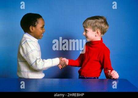 1980s TWO BOYS ONE AFRICAN-AMERICAN AND ONE CAUCASIAN SHAKING HANDS SMILING MAKING FRIENDS - kj11205 TRA001 HARS TEAMWORK PLEASED JOY LIFESTYLE HEALTHINESS HOME LIFE COPY SPACE FRIENDSHIP HALF-LENGTH INSPIRATION CARING MALES SPIRITUALITY CONFIDENCE SUCCESS WIDE ANGLE HAPPINESS WELLNESS CHEERFUL STRENGTH AFRICAN-AMERICANS AFRICAN-AMERICAN AND EXCITEMENT PROGRESS BLACK ETHNICITY PRIDE OPPORTUNITY SMILES CONNECTION CONCEPTUAL JOYFUL SUPPORT COOPERATION GROWTH JUVENILES TOGETHERNESS BUDDIES CAUCASIAN ETHNICITY OLD FASHIONED AFRICAN AMERICANS Stock Photo