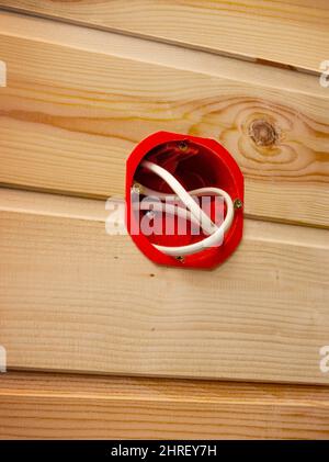 Plastic nest for an indoor socket in a wall sheathed with wooden lath Stock Photo