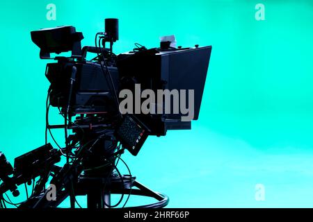 The camera on the tripod, led floodlight, prompter and a monitor on a green background. The chroma key. Green screen Stock Photo