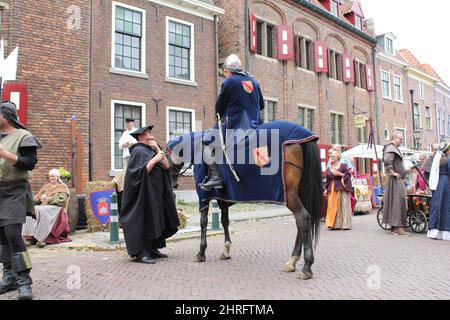 a knight on horseback walks in the streets during medieval times festivities in summer Stock Photo