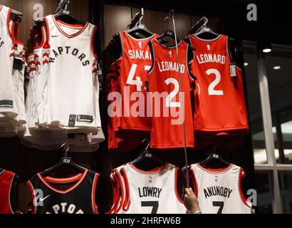 A man makes NBA jerseys for newly-acquired Toronto Raptors player Kawhi  Leonard at the Real Sports Apparel store at the Scotiabank Arena, in Toronto,  Friday July 20, 2018. THE CANADIAN PRESS/Mark Blinch