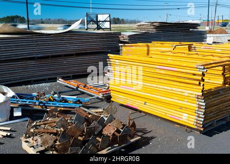 Horizontal shot of unassembled scaffolding stacked on a construction job site. Stock Photo