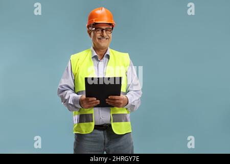 Construction site engineer with a reflective vest isolated over blue background Stock Photo