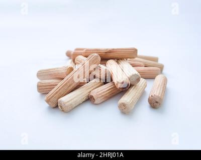 Wooden dowels for assembling furniture on white background. Front view. Selective focus Stock Photo