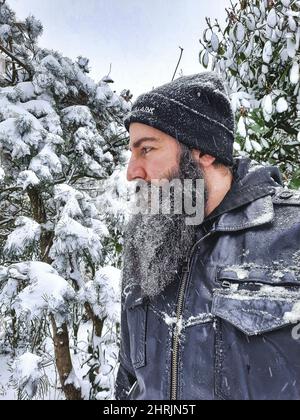 Portrait of the young Caucasian bearded man in the winter forest Stock Photo