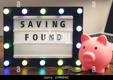 Saving Found written on marquee lightbox with piggy bank next to - pocket money concept. High quality photo Stock Photo