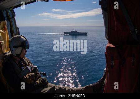 Pacific Ocean. 9th Feb, 2022. Naval Aircrewman (Helicopter) 1st Class Jake Sampson, assigned to Helicopter Sea Combat Squadron (HSC) 21, currently embarked on amphibious assault ship USS Makin Island (LHD 8), rides in an MH-60S Sea Hawk, Feb. 9. Makin Island is underway conducting routine operations in U.S. 3rd Fleet. Credit: U.S. Navy/ZUMA Press Wire Service/ZUMAPRESS.com/Alamy Live News Stock Photo