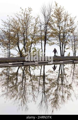 A woman takes a stroll along a pathway between the Richelieu River and the Chambly Canal Wednesday, Oct. 17, 2007 in St-Jean-sur-Richelieu, Quebec, Canada. (AP Photo/Paul Chiasson, The Canadian Press)