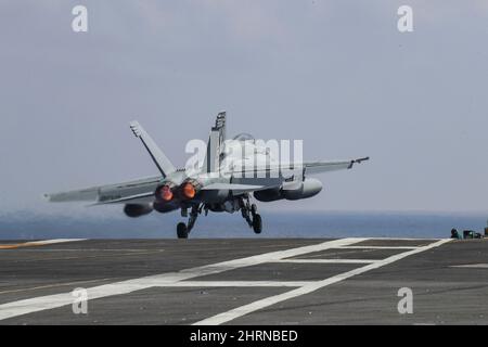 PHILIPPINE SEA (Feb. 24, 2022) An F/A-18E Super Hornet, assigned to the 'Tophatters' of Strike Fighter Squadron (VFA) 14, launches from the flight deck of the Nimitz-class aircraft carrier USS Abraham Lincoln (CVN 72). Abraham Lincoln Strike Group is on a scheduled deployment in the U.S. 7th Fleet area of operations to enhance interoperability through alliances and partnerships while serving as a ready-response force in support of a free and open Indo-Pacific region. (U.S. Navy photo by Mass Communication Specialist 3rd Class Javier Reyes) Stock Photo