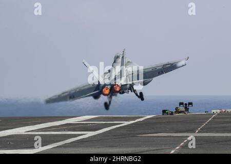 PHILIPPINE SEA (Feb. 24, 2022) An F/A-18F Super Hornet, assigned to the 'Black Aces' of Strike Fighter Squadron (VFA) 41, launches from the flight deck of the Nimitz-class aircraft carrier USS Abraham Lincoln (CVN 72). Abraham Lincoln Strike Group is on a scheduled deployment in the U.S. 7th Fleet area of operations to enhance interoperability through alliances and partnerships while serving as a ready-response force in support of a free and open Indo-Pacific region. (U.S. Navy photo by Mass Communication Specialist 3rd Class Javier Reyes) Stock Photo