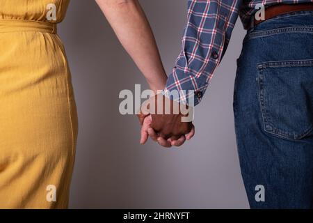 Close-up of the hands of a couple holding hands. Interracial couple, evolution of society Stock Photo