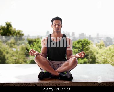 Seeking inner strength to match his outer strength. Full length shot of a man meditating in the lotus position. Stock Photo