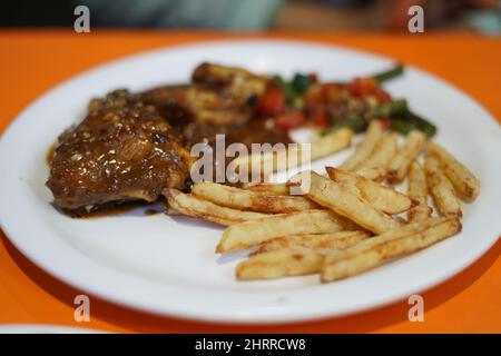 Buffalo chicken wings  french fries on white plate . Stock Photo