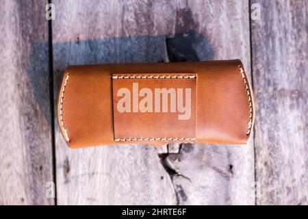Brown genuine leather glasses case handmade working on wood, Leather goggle bag Stock Photo