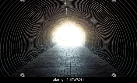 Dark black tunnel. Light at the end of tunnel. The movement along underpass Stock Photo