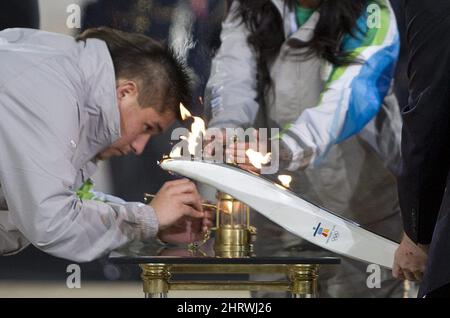 Olympic flame attendant Aronhiaies Herne transfers the Olympic Flame to a miner's lantern during a handover ceremony at the Panathenaic Stadium in Athens, Greece, Thursday, Oct. 29, 2009. The Olympic Flame will now travel overnight by plane to Victoria, B.C. and will land in Canada Oct. 30, 2009 to start a 106 day cross Canada torch relay ending in Vancouver for the opening ceremonies of the 2010 Winter Olympics. THE CANADIAN PRESS/Jonathan Hayward Stock Photo