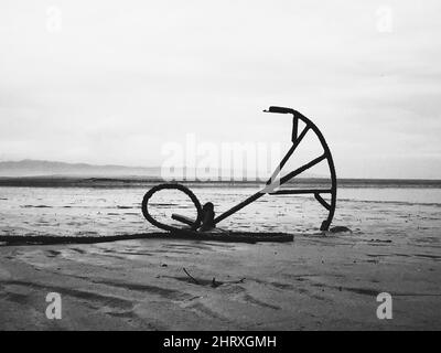 Grayscale shot of a anchor on a beach Stock Photo