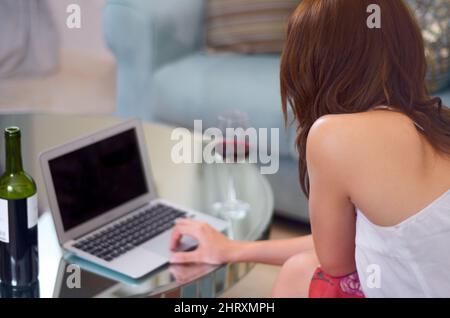 Surfing the net. Over the shoulder view of a woman working on her laptop. Stock Photo