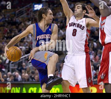 Phoenix Suns' Steve Nash (L) goes airborne as he makes a pass in